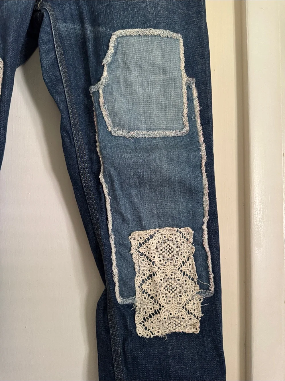 Free People skinny jeans with crochet lace and patching details. 32” inseam.